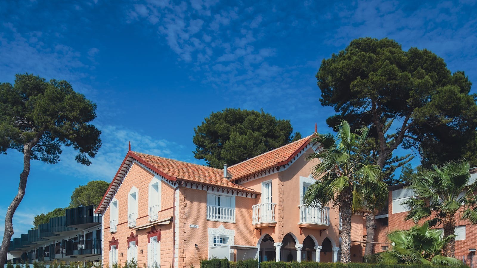Maison méditerranéenne aux tuiles orangées entourée de palmiers, exemple de meublé de tourisme en location saisonnière