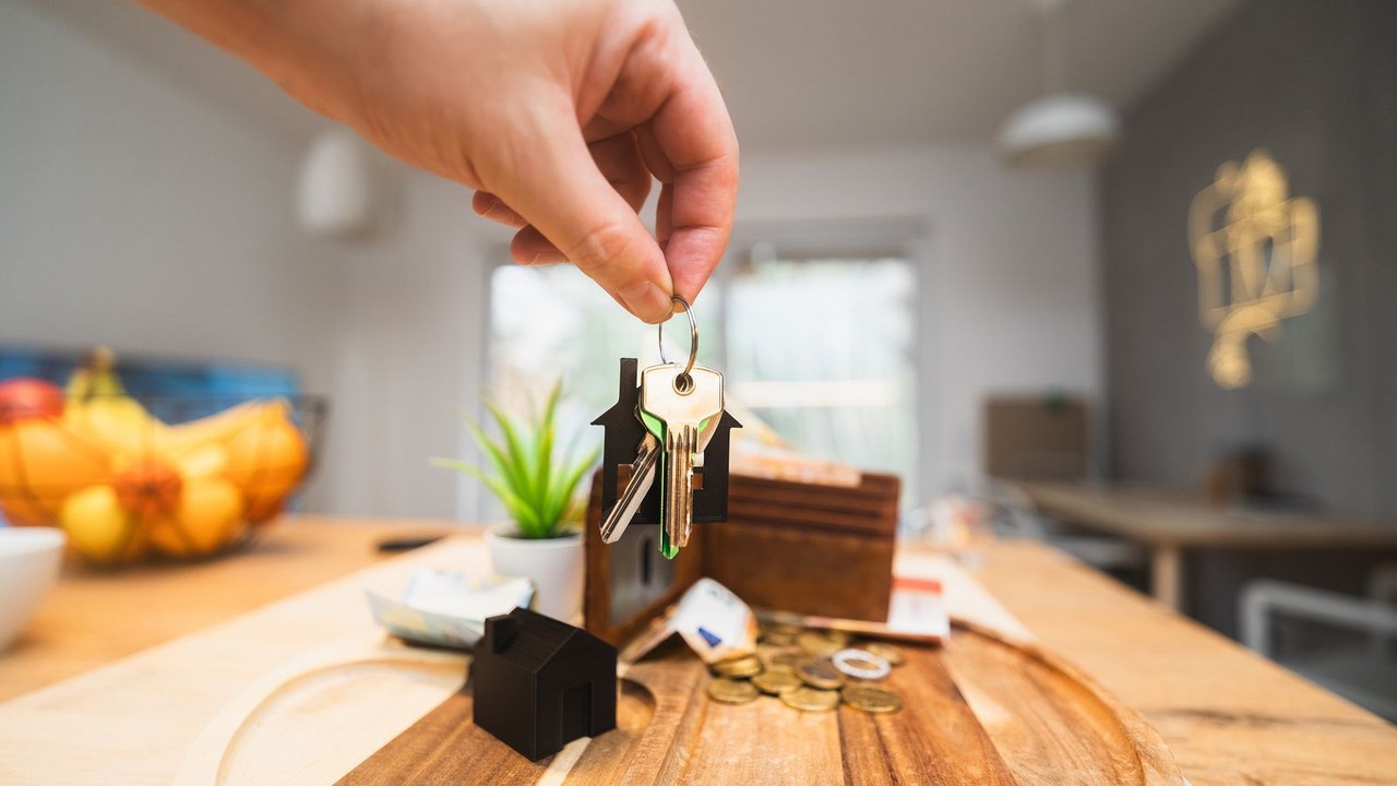 Main tenant des clés dans un intérieur lumineux - préavis de location locataire